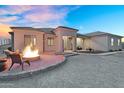 The exterior boasts a cozy fire pit with desert landscaping and a charming facade at 28204 N Royce Rd, Queen Creek, AZ 85144