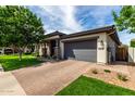 Well-maintained home with a spacious driveway and a two-car garage with gray doors at 2900 E Spring Wheat Ln, Gilbert, AZ 85296