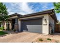 Home exterior featuring a large two-car garage and a beautifully bricked driveway at 2900 E Spring Wheat Ln, Gilbert, AZ 85296