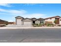 Charming home featuring a three-car garage and an inviting desert landscape, showcasing its appealing curb appeal at 40610 W Desert Fairways Dr, Maricopa, AZ 85138