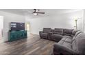 Spacious living room featuring plank flooring, a ceiling fan, and comfortable gray seating at 4445 E Coconino St, Phoenix, AZ 85044