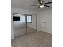Spacious bedroom featuring mirrored closet doors, neutral carpet, a ceiling fan, and bright natural light at 461 W Holmes Ave # 374, Mesa, AZ 85210