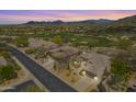 Aerial view of a home, golf course, and mountain views in a meticulously landscaped desert community at 6214 E Evening Glow Dr, Scottsdale, AZ 85266