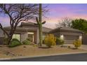 Charming single story home boasting desert landscaping and a neutral color palette at sunset at 6214 E Evening Glow Dr, Scottsdale, AZ 85266