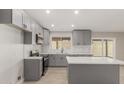 Modern kitchen with gray cabinets, quartz countertops, herringbone backsplash, and stainless steel appliances at 6335 E Brown Rd # 1098, Mesa, AZ 85205