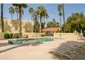 Inviting community pool area with lounge chairs, tables, and beautifully landscaped surroundings at 6540 N 7Th Ave # 46, Phoenix, AZ 85013
