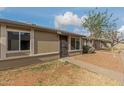Property featuring pathway to the front door, tan stucco exterior, and well maintained rock landscaping at 6711 W Osborn Rd # 68, Phoenix, AZ 85033