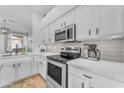 Bright, modern kitchen featuring white cabinets, stainless steel appliances, and quartz countertops at 735 W Ivanhoe St, Gilbert, AZ 85233