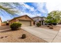Single-story home featuring desert landscaping, a two-car garage, and an inviting, clean driveway at 749 E Desert Moon Trl, San Tan Valley, AZ 85143