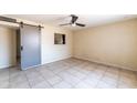 The bright bedroom features tile flooring, a ceiling fan and pass-through to kitchen at 7513 E Roosevelt St, Scottsdale, AZ 85257
