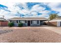 A charming single story home with a long driveway and desert landscaping at 7513 E Roosevelt St, Scottsdale, AZ 85257