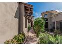 Exterior shot showcasing a stucco house and desert landscaping with a charming walkway to an arched entrance at 9270 E Thompson Peak Pkwy # 315, Scottsdale, AZ 85255
