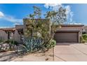 Inviting home showcasing desert landscaping, a two-car garage, and a warm, neutral color palette at 9270 E Thompson Peak Pkwy # 315, Scottsdale, AZ 85255