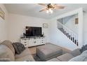 Cozy living room with gray sectional sofa, ceiling fan, and a TV on a white media console at 10221 W Puget Ave, Peoria, AZ 85345