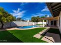 Lush backyard with artificial grass, sparkling pool, and covered patio perfect for entertaining at 10836 N 108Th N Pl, Scottsdale, AZ 85259