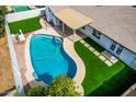 Stunning aerial view of a private backyard featuring a sparkling pool, green turf, and a covered patio perfect for entertaining at 10836 N 108Th N Pl, Scottsdale, AZ 85259