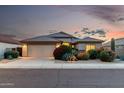 Charming single-Gathering home at twilight featuring mature landscaping, a tile roof, and a well-maintained front yard at 12526 S 176Th Ave, Goodyear, AZ 85338