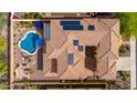 Aerial view of the tile roof with solar panels, blue pool, and courtyard of a luxury home at 13336 W Via Caballo Blanco --, Peoria, AZ 85383