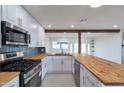 Updated kitchen with stainless appliances, butcher block countertops, and a tile backsplash, seamlessly blending style at 1410 W Morrow Dr, Phoenix, AZ 85027