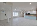 Spacious living area with light tile flooring, abundant natural light, and an open floor plan to the kitchen at 1410 W Morrow Dr, Phoenix, AZ 85027