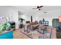 Bright living room featuring a ceiling fan, wood-look floors and colorful rug at 1643 W Harmont Dr, Phoenix, AZ 85021