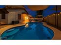 Inviting pool and covered patio area perfect for relaxing and entertaining outdoors at twilight at 18325 W Port Au Prince Ln, Surprise, AZ 85388