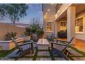 Inviting backyard with a cozy fire pit, stylish seating, manicured landscaping, and privacy wall at 21073 W Sunrise Ln, Buckeye, AZ 85396