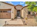 Home exterior showing stone accents, desert landscaping, an arched entryway and walkway lighting at 27614 N 129Th Ln, Peoria, AZ 85383