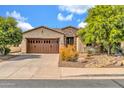 Charming home featuring a stone facade, a two car garage, desert landscaping and a paver driveway at 27614 N 129Th Ln, Peoria, AZ 85383