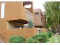 Modern condo building with desert landscaping, balconies, and exterior stairway at 3500 N Hayden Rd # 2103, Scottsdale, AZ 85251