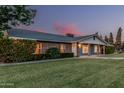 Classic home with brick and blue siding, a well-manicured lawn, and mature hedges at sunset at 370 E Redfield Rd, Chandler, AZ 85225