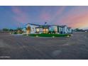 Beautiful custom home with circular driveway, lush turf, and stunning exterior lighting at dusk at 447 W Judd Rd, San Tan Valley, AZ 85143