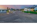 An inviting, custom home with a circular driveway and beautifully lit landscaping at dusk at 447 W Judd Rd, San Tan Valley, AZ 85143