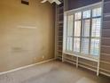 An empty bedroom features light brown walls, carpet and bright window at 4843 E Estevan Rd, Phoenix, AZ 85054