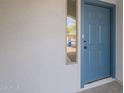 Inviting front entry featuring a stylish blue door with modern hardware and textured white walls at 507 W Magdalena Ln, Phoenix, AZ 85041