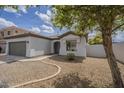 Attractive single-story home featuring a gravel front yard, walkway to front door, and lush tree at 507 W Magdalena Ln, Phoenix, AZ 85041
