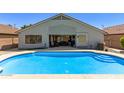 A refreshing blue pool is nestled against the back of the home, leading to an indoor-outdoor living space at 5432 N Ormondo Way, Litchfield Park, AZ 85340