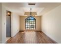 Bright dining room area with a large window, modern light fixture, and hardwood floors at 6252 E Aire Libre Ln, Scottsdale, AZ 85254