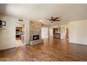 Open living area with a stone fireplace, hardwood floors, and views into the kitchen and bar area at 6252 E Aire Libre Ln, Scottsdale, AZ 85254