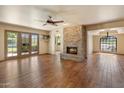 Spacious living room featuring a stone fireplace, ceiling fan and beautiful hardwood floors at 6252 E Aire Libre Ln, Scottsdale, AZ 85254