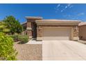 Charming single-story home featuring a stone facade, two-car garage, and well-maintained landscaping at 9032 W Sierra Pinta Dr, Peoria, AZ 85382