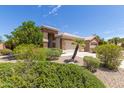 Attractive home with desert landscaping, stone facade, and a two-car garage at 9032 W Sierra Pinta Dr, Peoria, AZ 85382