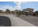 Well-manicured landscaping complements this charming single-story home and driveway at 9698 S 183Rd Ave, Goodyear, AZ 85338