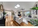 Bright living room featuring hardwood floors, skylights, modern decor and an open floor plan at 10713 W Santa Fe Dr, Sun City, AZ 85351