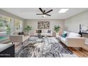 Spacious living room with hardwood floors, stylish rug, neutral palette and lots of natural light at 10713 W Santa Fe Dr, Sun City, AZ 85351