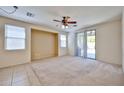 Bright carpeted bedroom with a ceiling fan and sliding glass door to the patio at 14214 W Ventura St, Surprise, AZ 85379