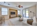 Bright living room features a ceiling fan, tile flooring, and sliding glass doors to the backyard at 14214 W Ventura St, Surprise, AZ 85379