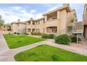 Charming condo featuring lush green lawns, desert landscaping, and private balconies at 16013 S Desert Foothills Pkwy # 2055, Phoenix, AZ 85048