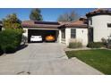 Spacious garage with two cars, solar panels on the roof, and a well-maintained driveway and landscaping at 16155 N 171St Dr, Surprise, AZ 85388