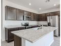 Modern kitchen featuring stainless steel appliances, dark cabinetry, and a spacious center island with a granite countertop at 18007 W Camino De Oro --, Surprise, AZ 85387
